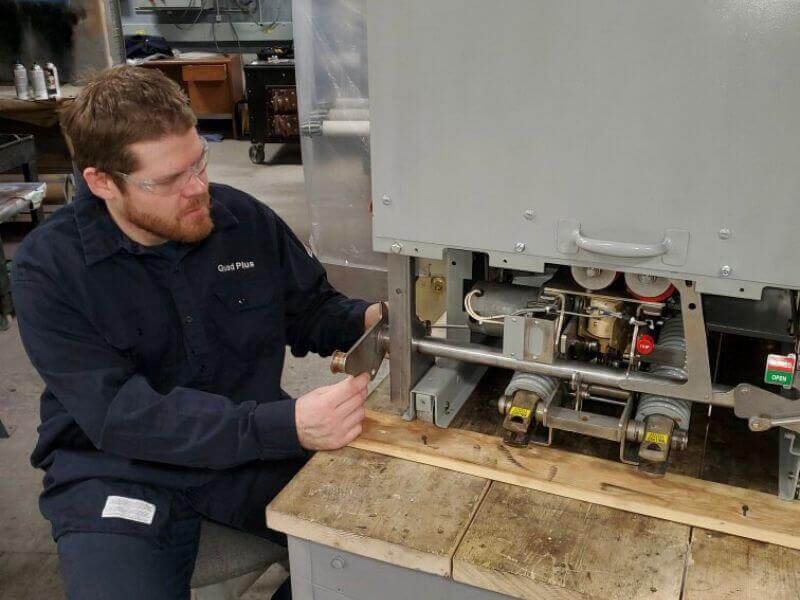 technician servicing an air circuit breaker on table