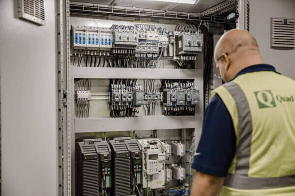 technician inspecting control systems integration panel