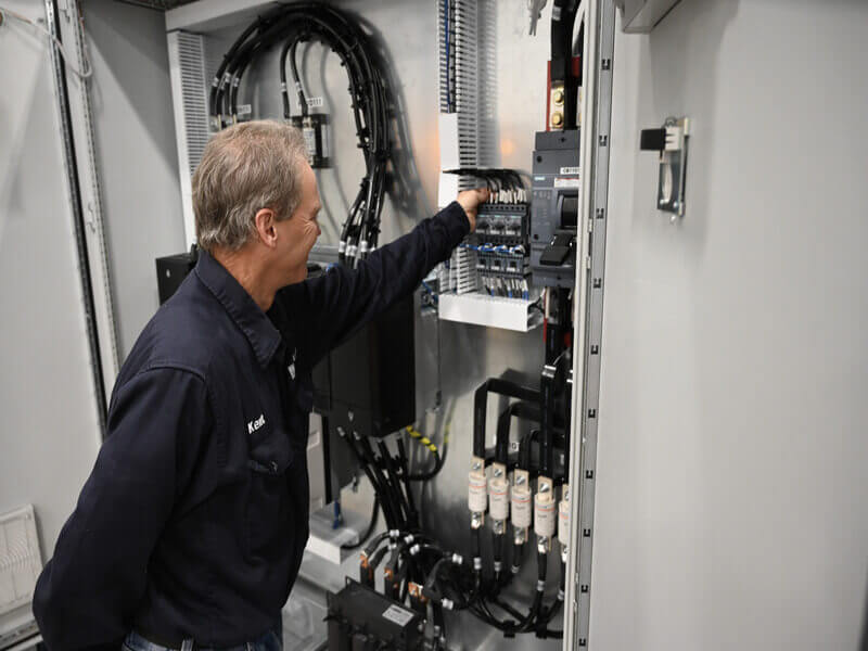 technician performing detailed checks on equipment during the electrical commissioning process.