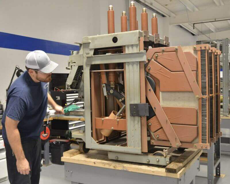 technician inspecting ge magne blast circuit breaker unit