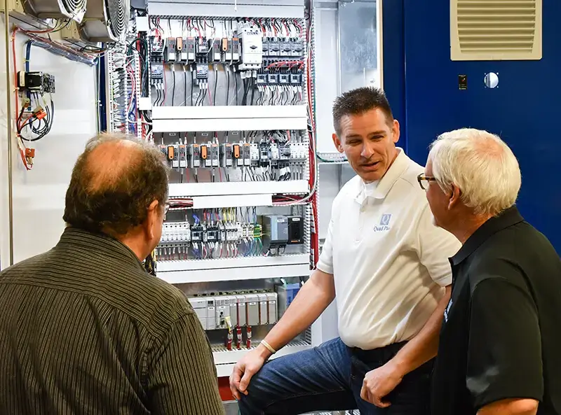 integrated-control-system control system integration team discussing panel wiring