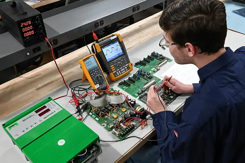 engineer performing vfd repair on circuit boards