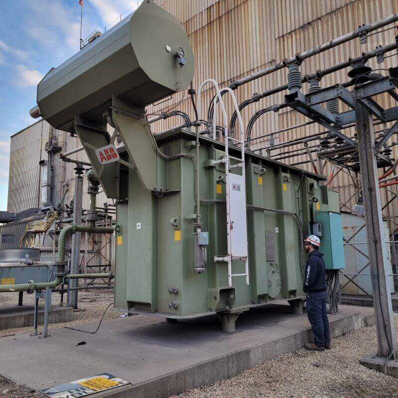 engineer performing transformer oil sampling on-site