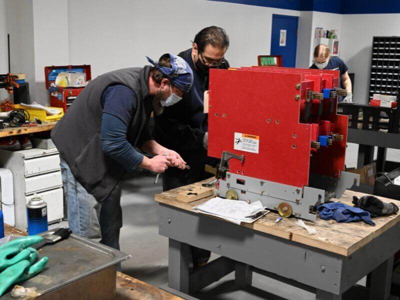 technicians doing switchgear maintenance in workshop